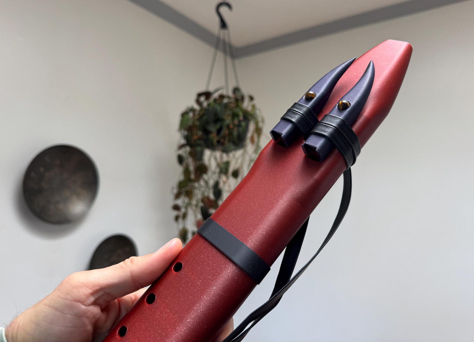 Crimson Drone Flute held in hand showing scale and finger holes