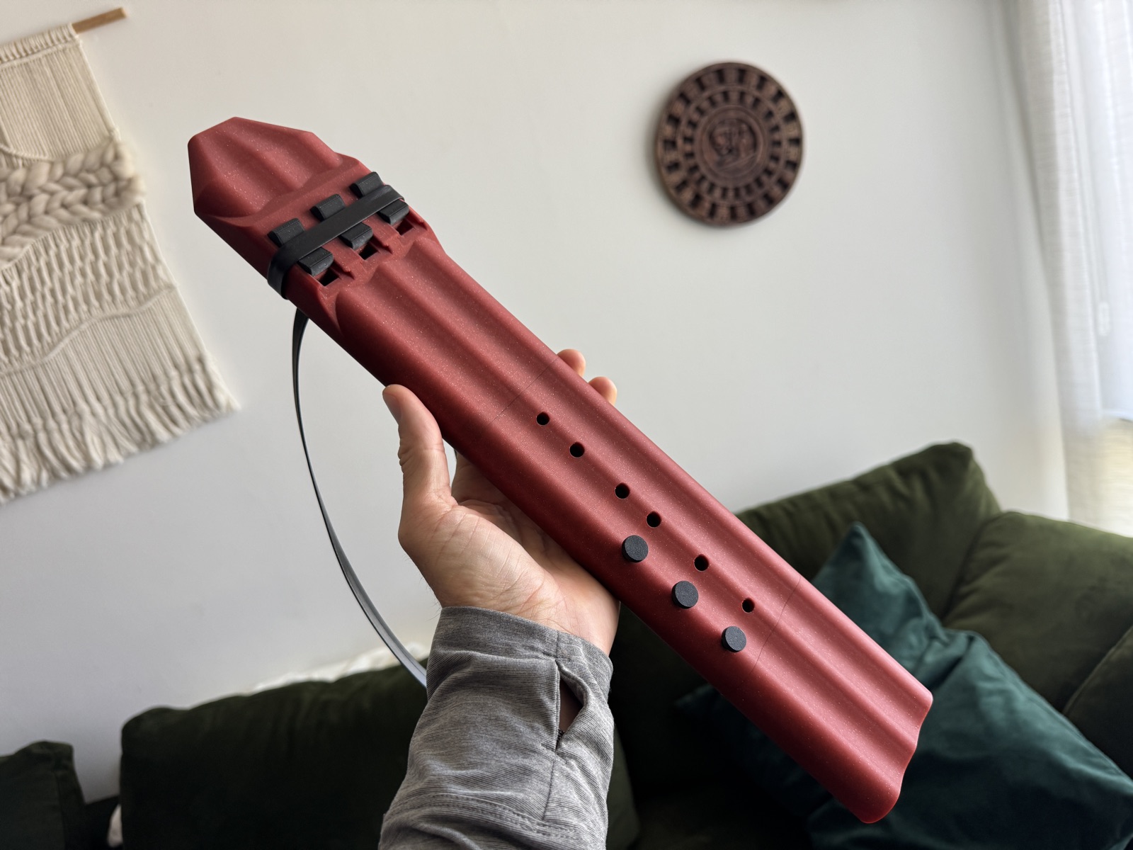 Crimson triple drone flute held in hand