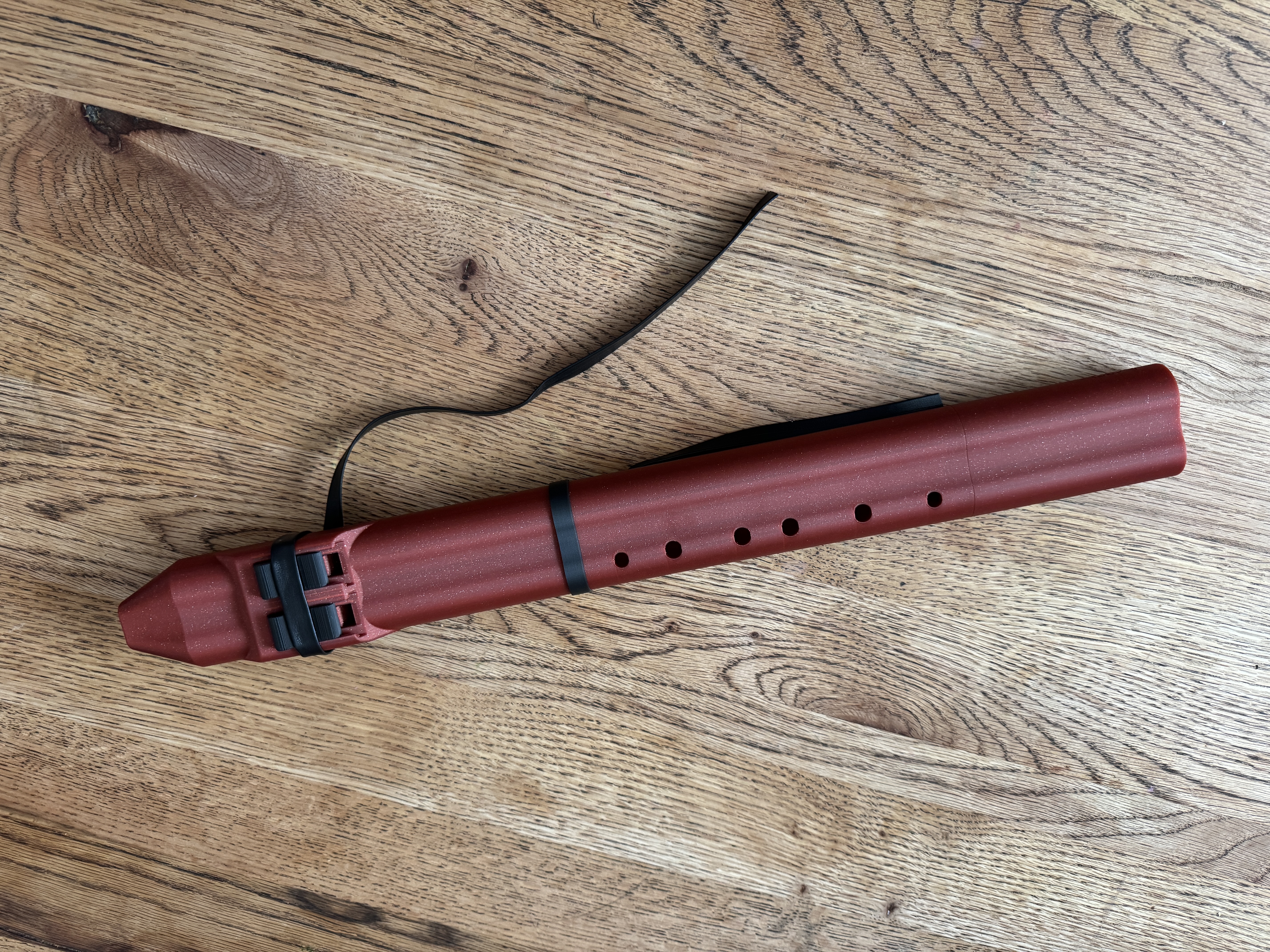 Top-down flat-lay of the Drone Flute A on oak floor